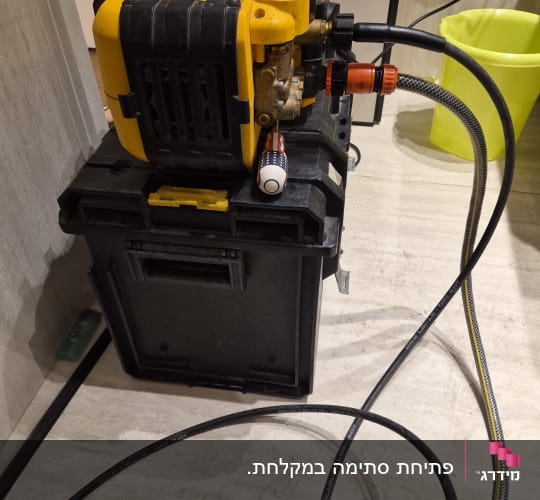 מכונת שטיפה צהובה עם צינורות על רצפה